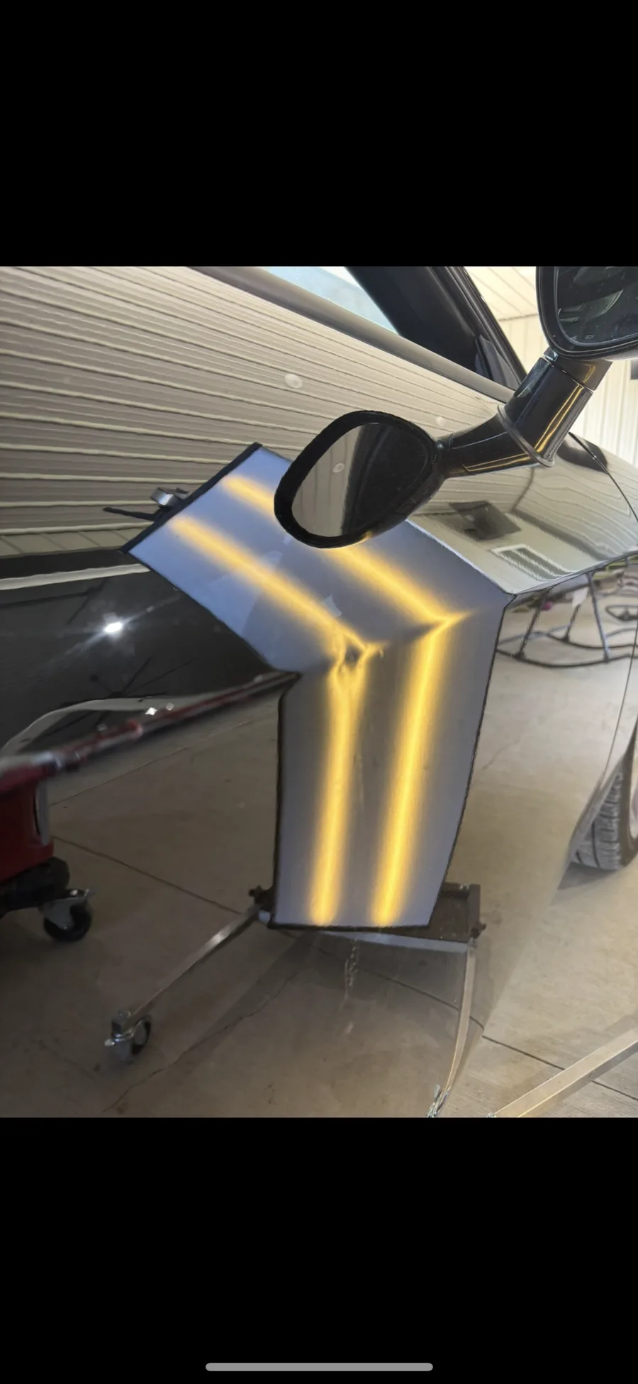 Vehicle body panel removed from the car and positioned on a stand for LED line-board inspection