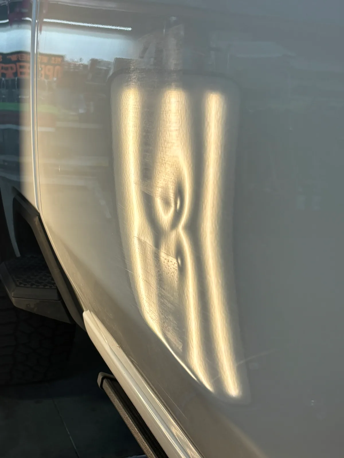 Close-up of hail damage on a customer vehicle under LED line-board inspection