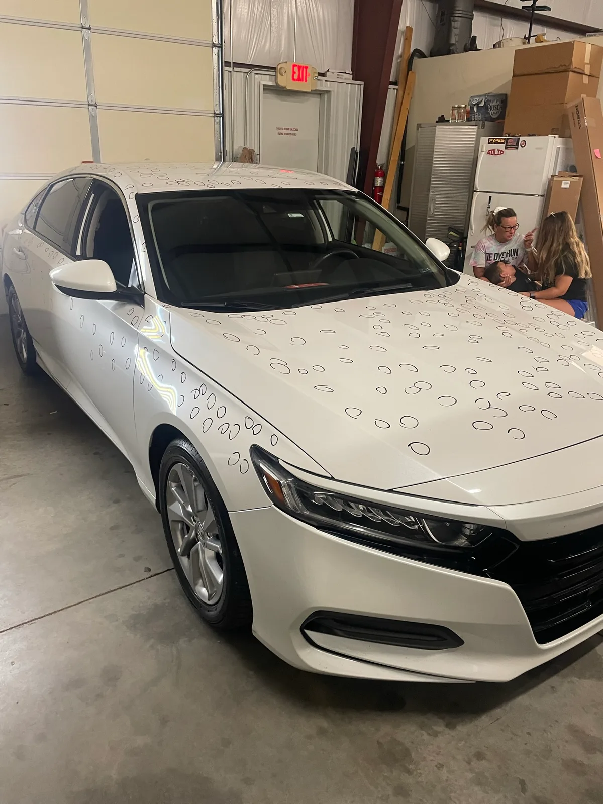 White Honda Accord with hail dent circles mapped across hood and roof during damage assessment at Hail Solutions Olathe