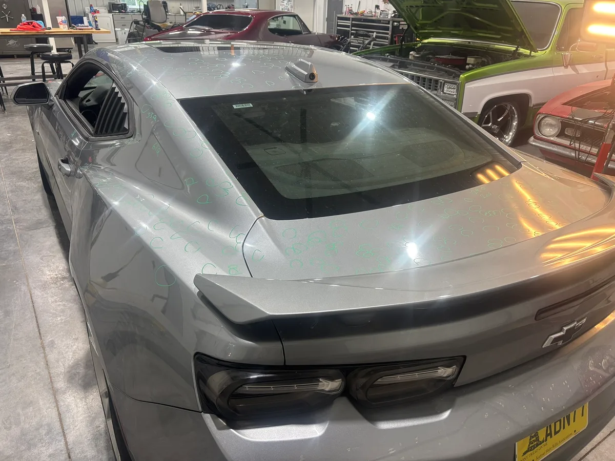 Hail-damaged Chevrolet Camaro SS with green dent-mapping circles on all panels at the Hail Solutions shop in Olathe